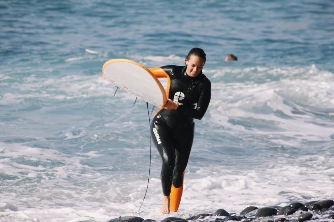 Estudiante de surf aprendiendo a remar en las olas de La Palma